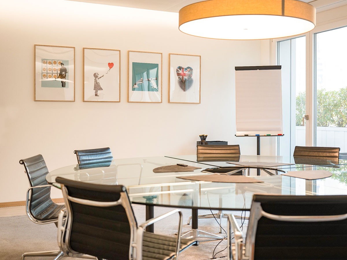 Meeting-Raum mit rundem Glastisch und Designer-Stühlen