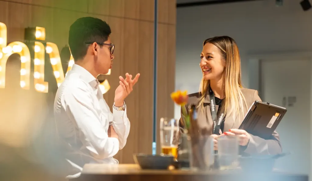 Ein Event-Teilnehmer im Gespräch mit Julia Pircher, Head of Community Management bei Westhive