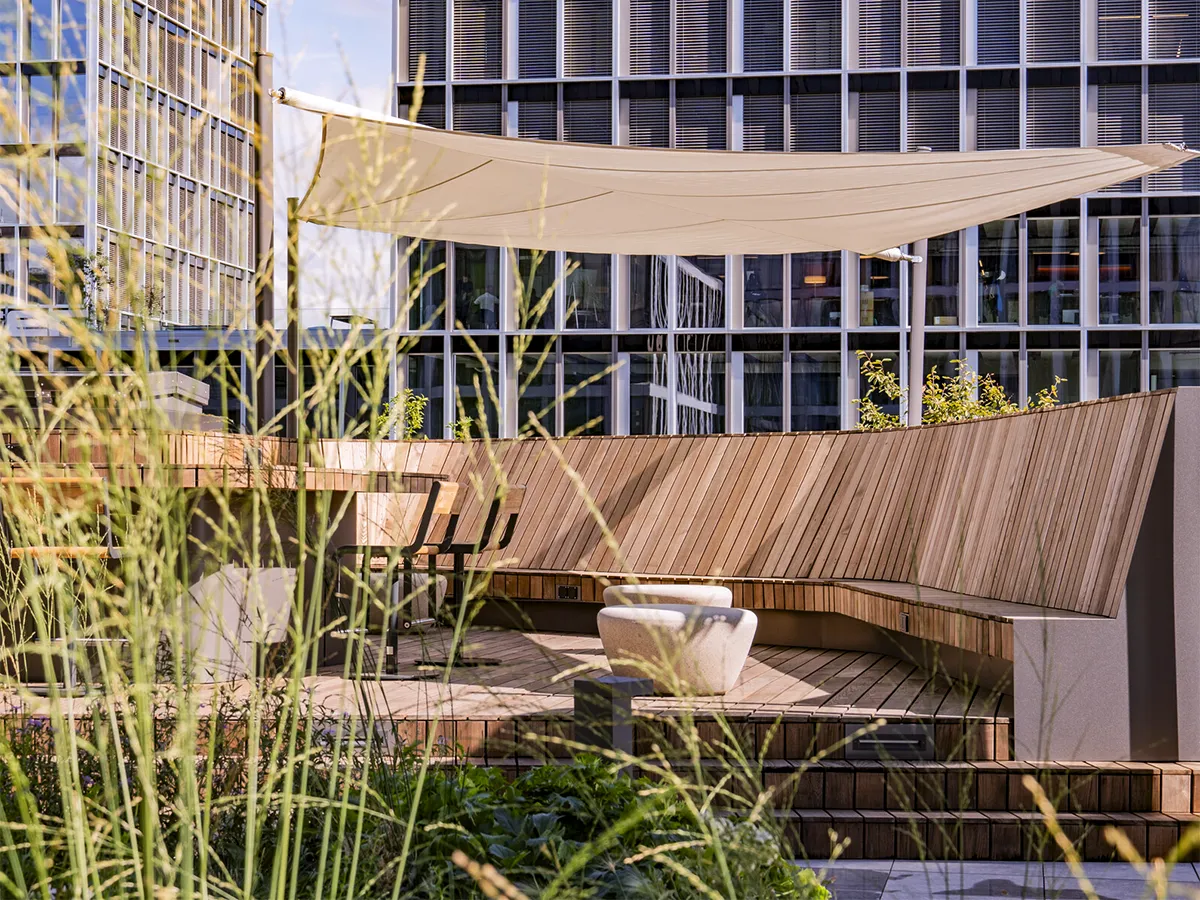 Dachterrasse mit Sitzbänken, Sonnensegel und Pflanzen