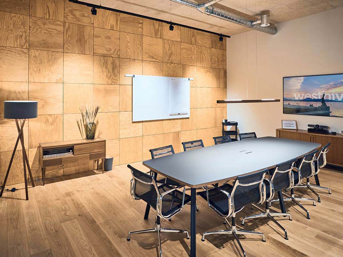 Ein moderner, hochwertiger Meeting-Raum mit Parkett, holzverkleideten Wänden und Designer-Stühlen