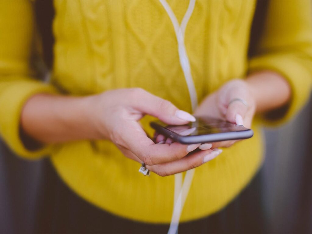 A woman is holding her smartphone