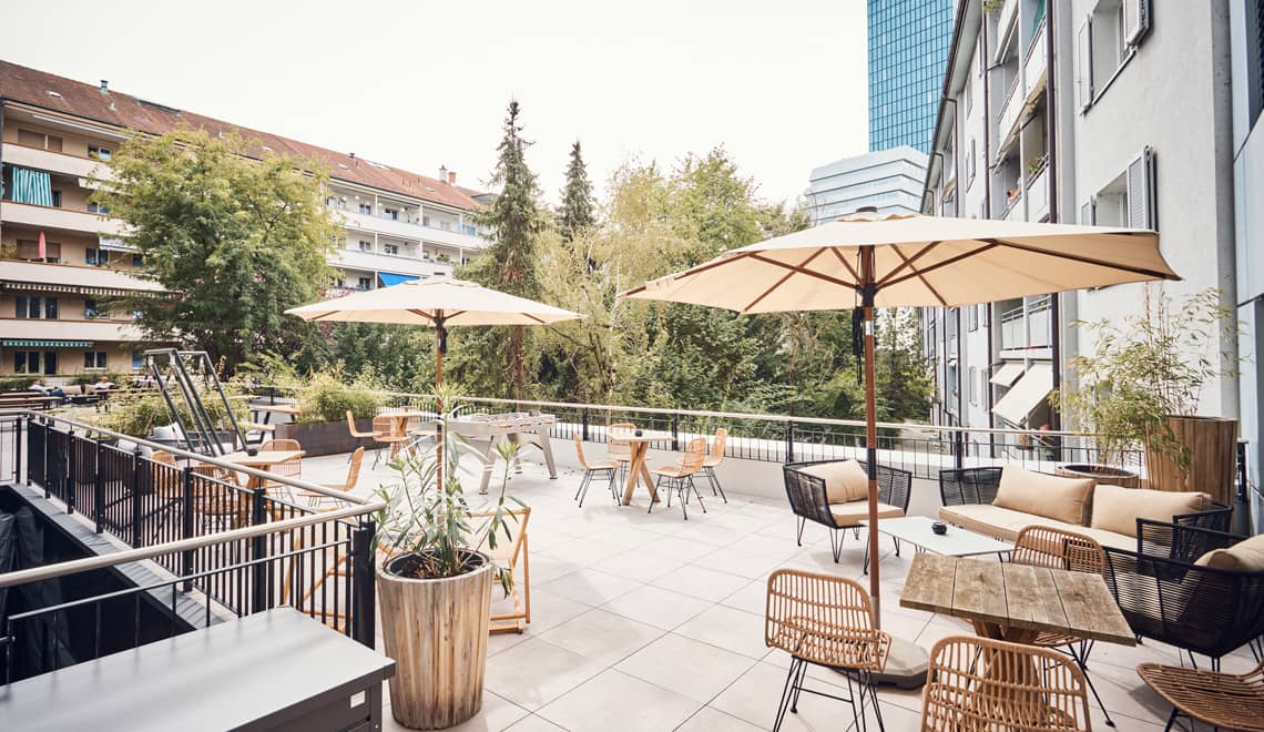 Terrasse mit Sonnenschirmen und Blick auf den Messeturm
