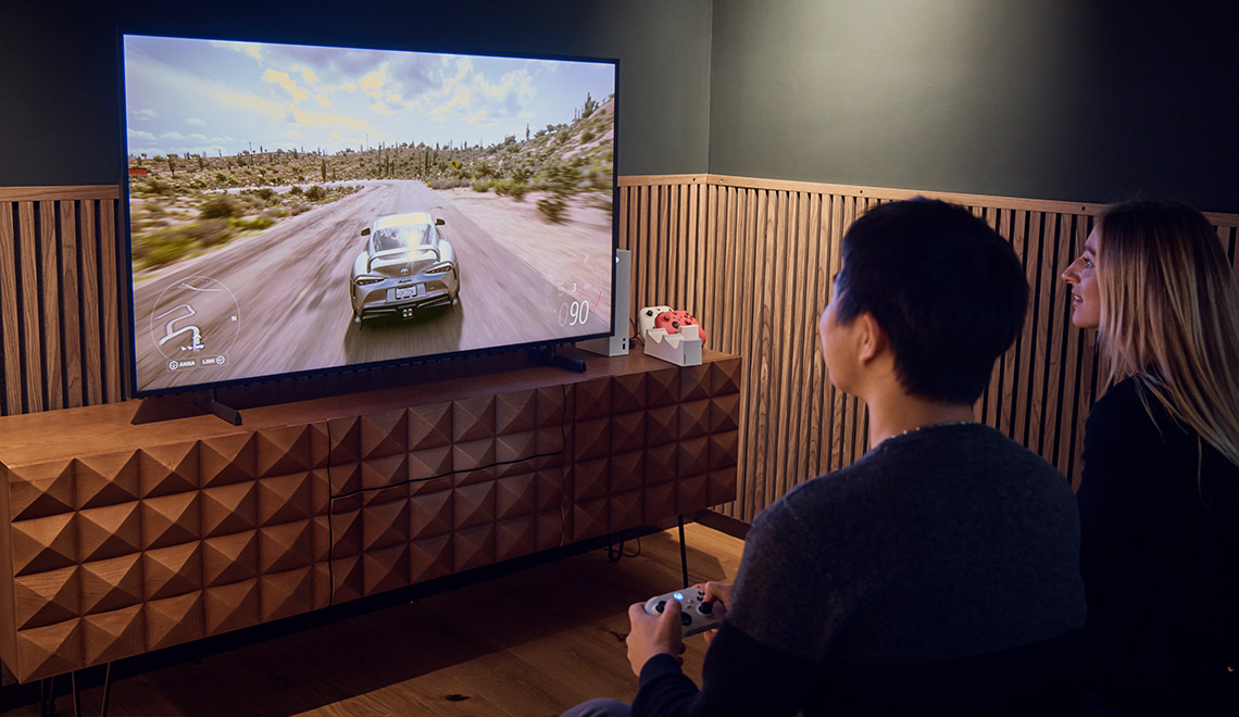 Eine Frau und ein Mann spielen ein Racing Game